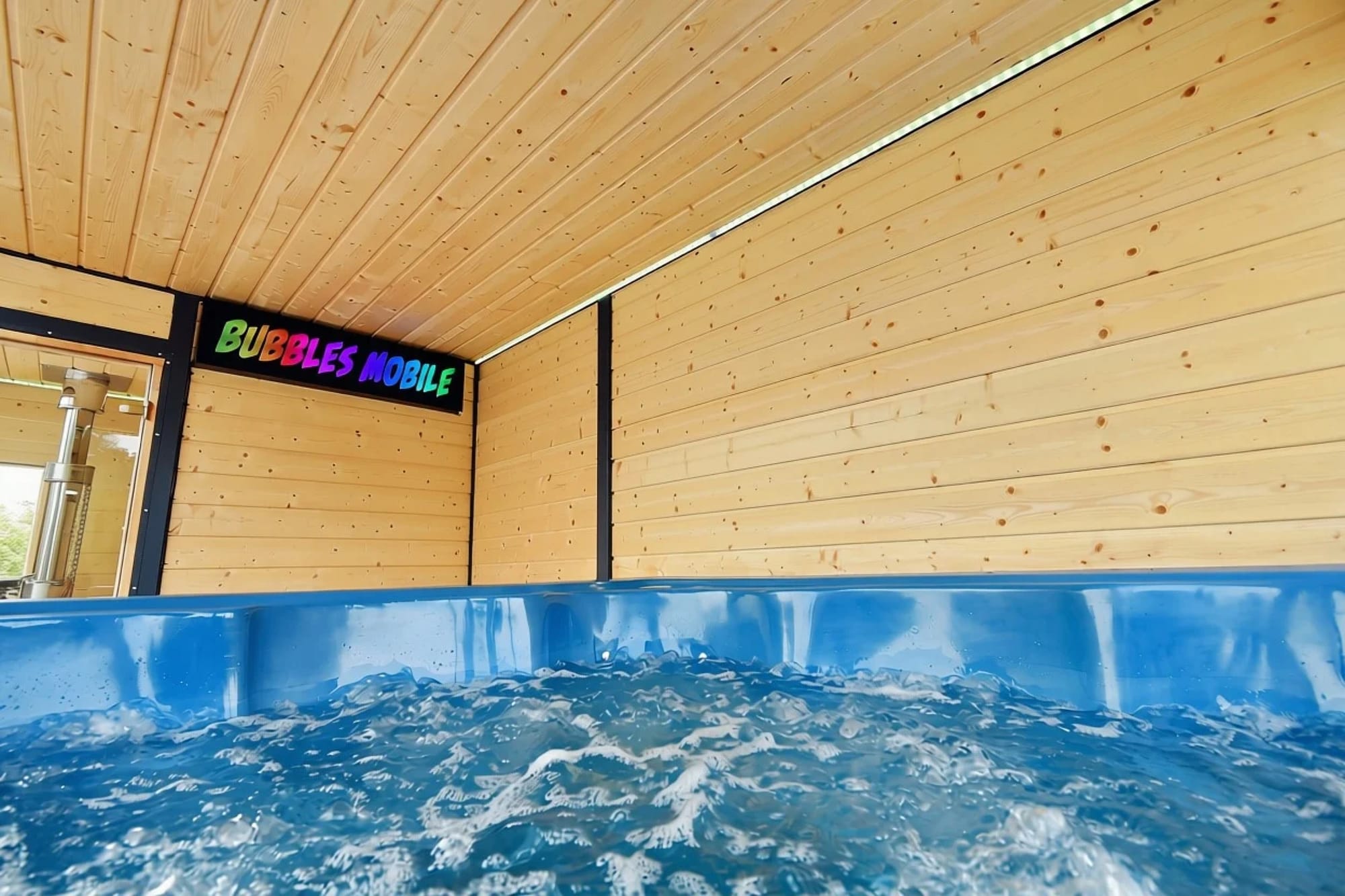 Niebieskie jacuzzi z wirującą wodą, nad nim ściana i sufit z jasnego drewna.